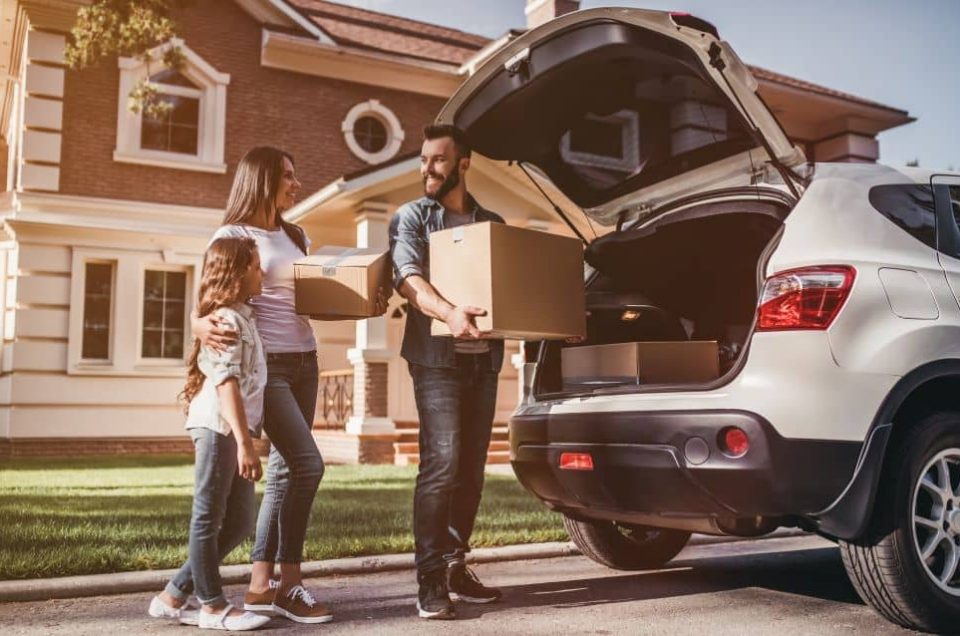 Family loading boxes to car.